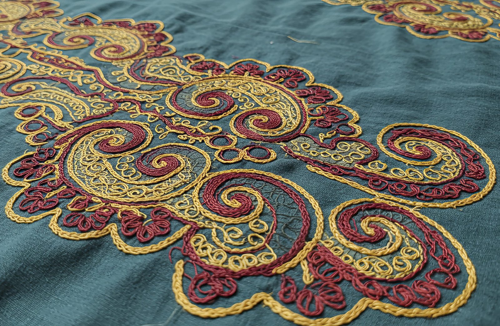 intricate embroidery: golden and crimson paisley motifs on teal
